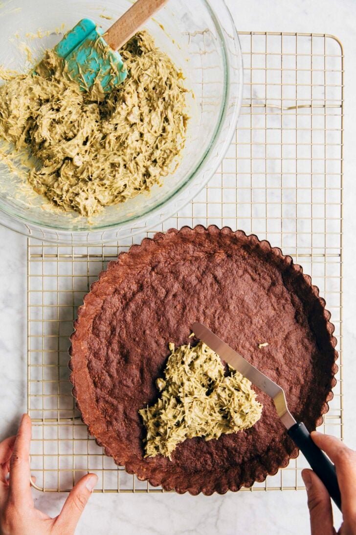 Photo showing Michelle from Hummingbird High scooping the kataifi filling into the baked tart crust
