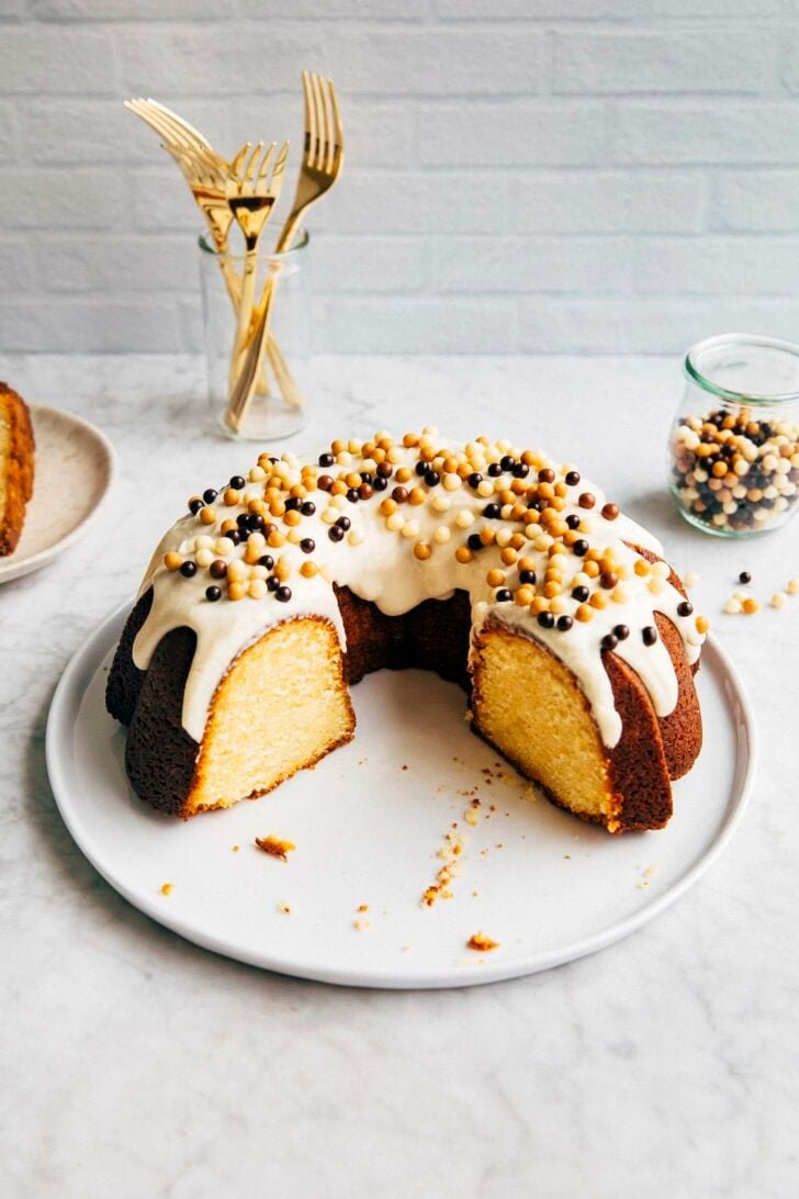 photo of banana pudding bundt cake on white round plate sliced