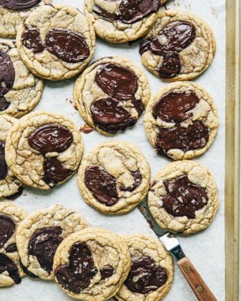 A photo of chocolate chip cookies on a gold sheet pan.