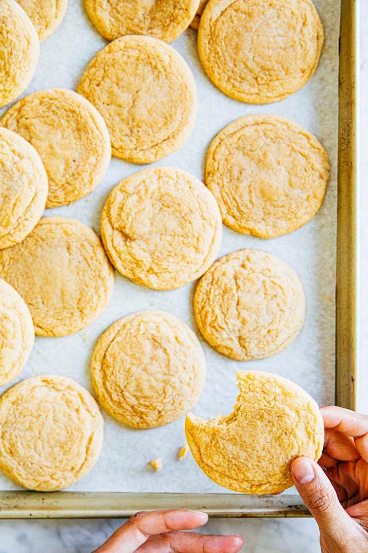 photo of hand holding a maple sugar cookie with a bite taken out