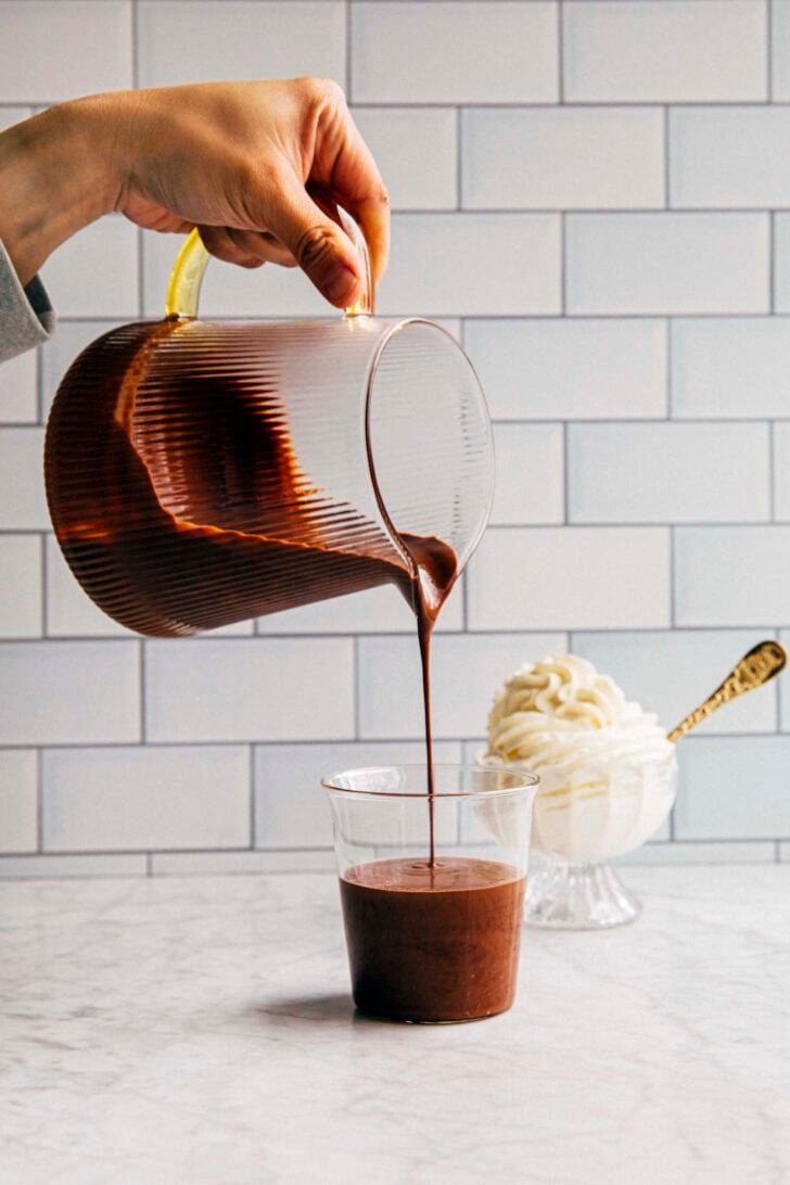 photo of michelle from hummingbird high pouring french hot chocolate into a clear tumbler