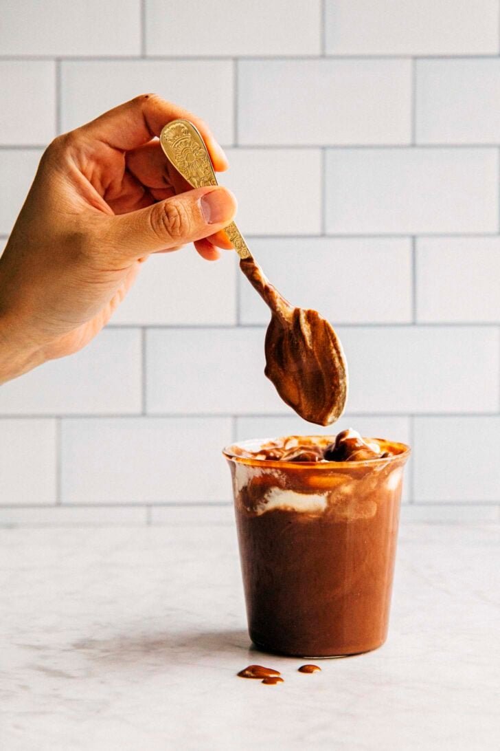 photo of michelle from hummingbird high dipping a gold spoon into the french hot chocolate