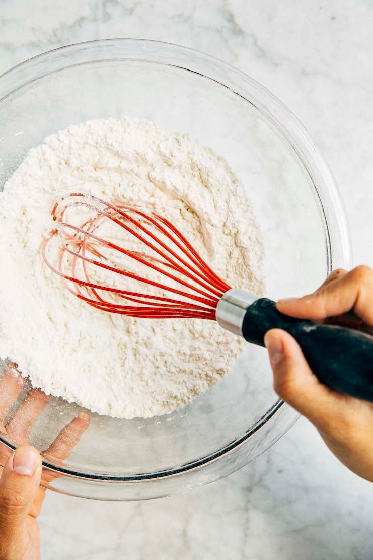 photo of michelle from hummingbird high making homemade cake flour in a glass bowl with a red whisk