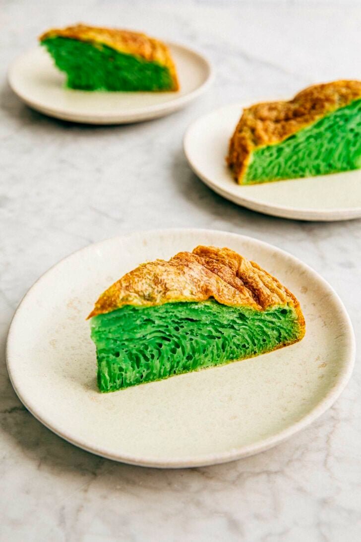 photo of three vietnamese honeycomb cake slices on white plates on a marble tabletop