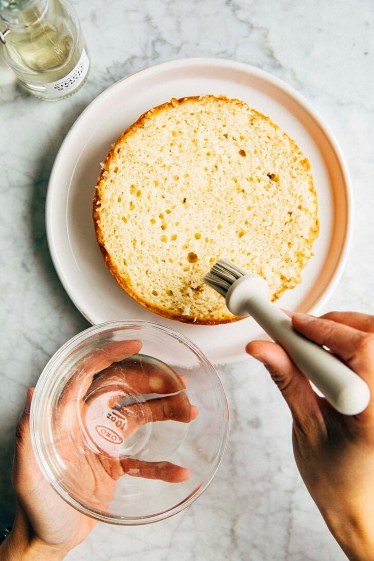 photo of michelle from hummingbird high brushing a cake with homemade simple syrup