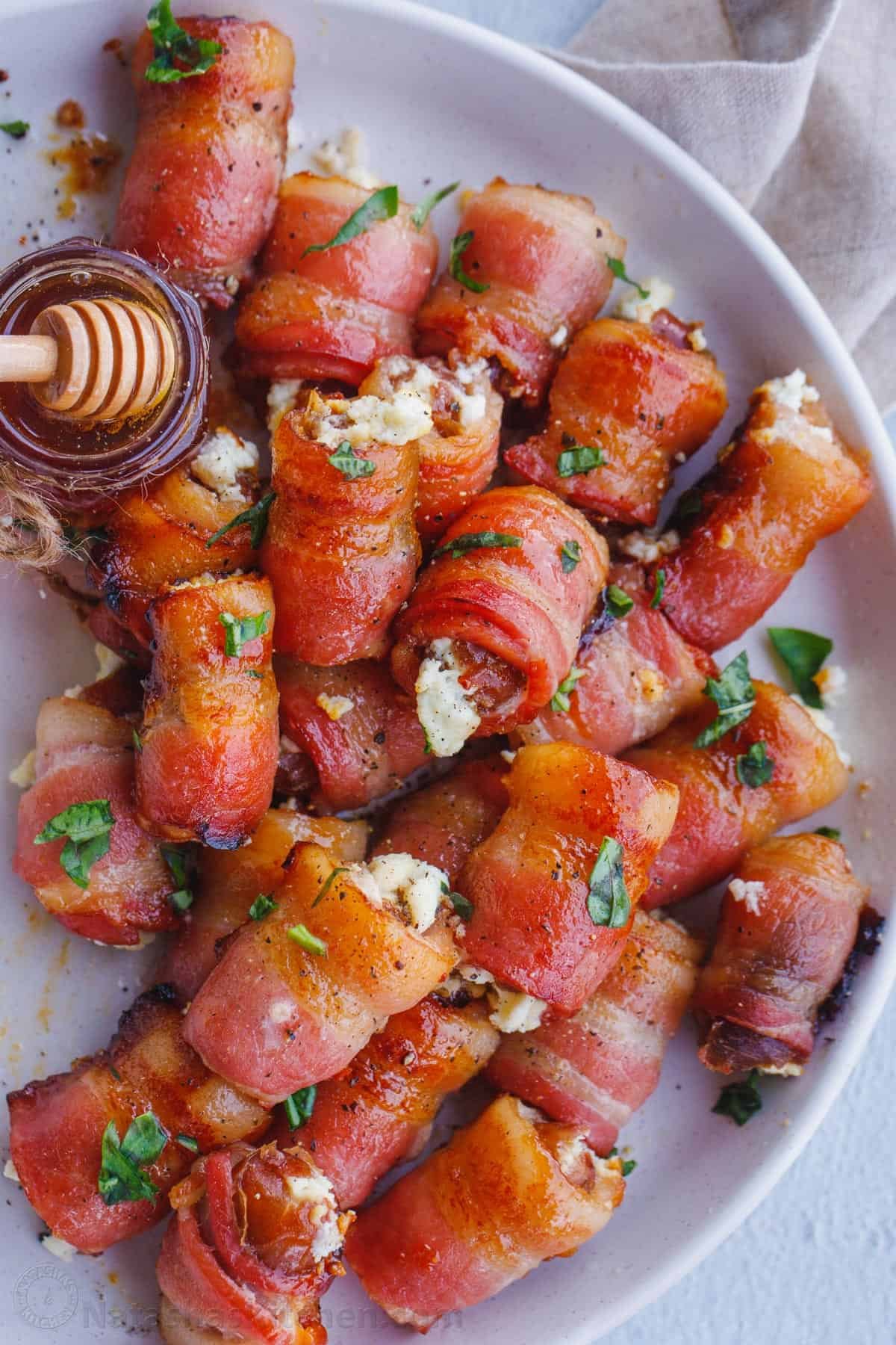 Stuffed Dates are an irresistible appetizer stuffed with goat cheese and wrapped in crispy bacon. This stuffed dates recipe is always a hit at parties. Stuffed dates served on a platter