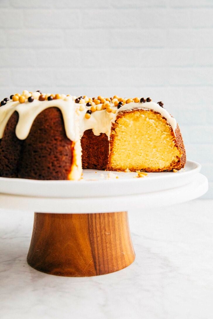 photo of banana bundt cake on a cake stand sliced showing the interior yellow crumb