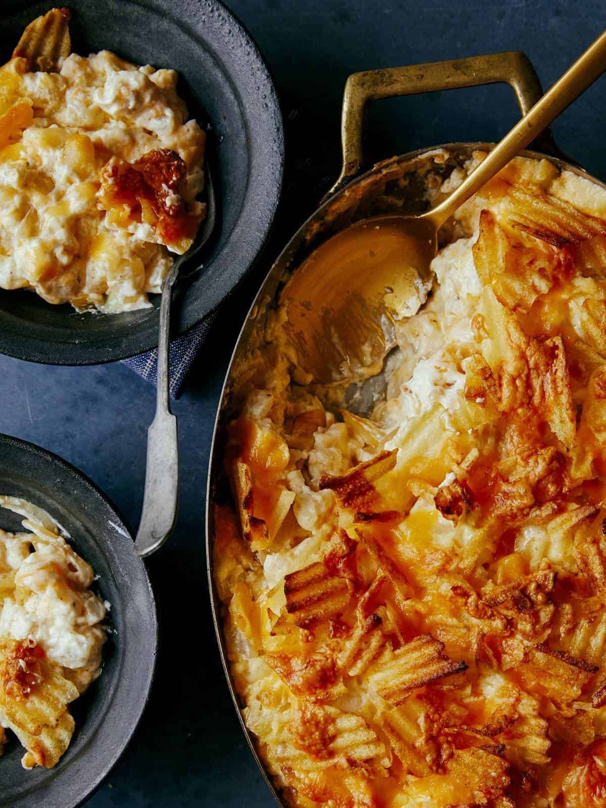 Cheesy Potato Casserole with a potato chip crust served into a couple of bowls.