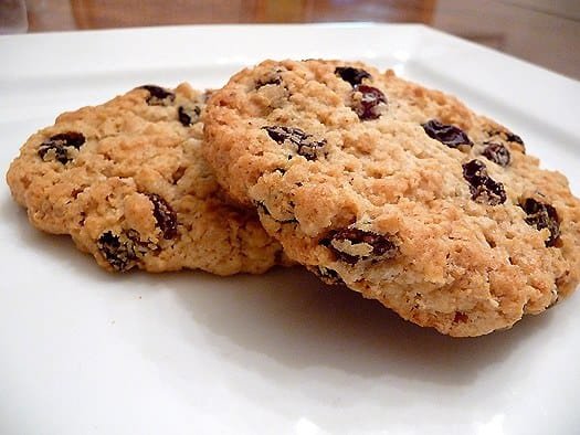 2 oatmeal raisin cookies on a white plate.