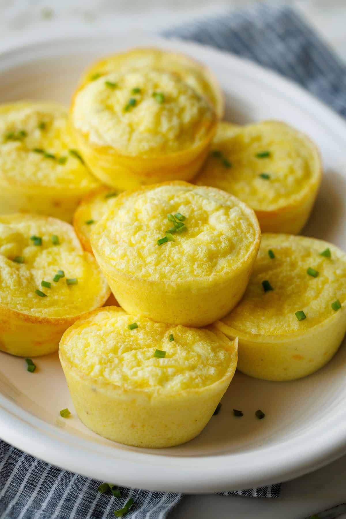 My Cottage cheese egg bites are as good as Starbucks egg bites recipe, but with less hassle! Choose your favorite mix-ins to make them yours. Cottage Cheese egg bites recipe stacked on a white plate with chives on top