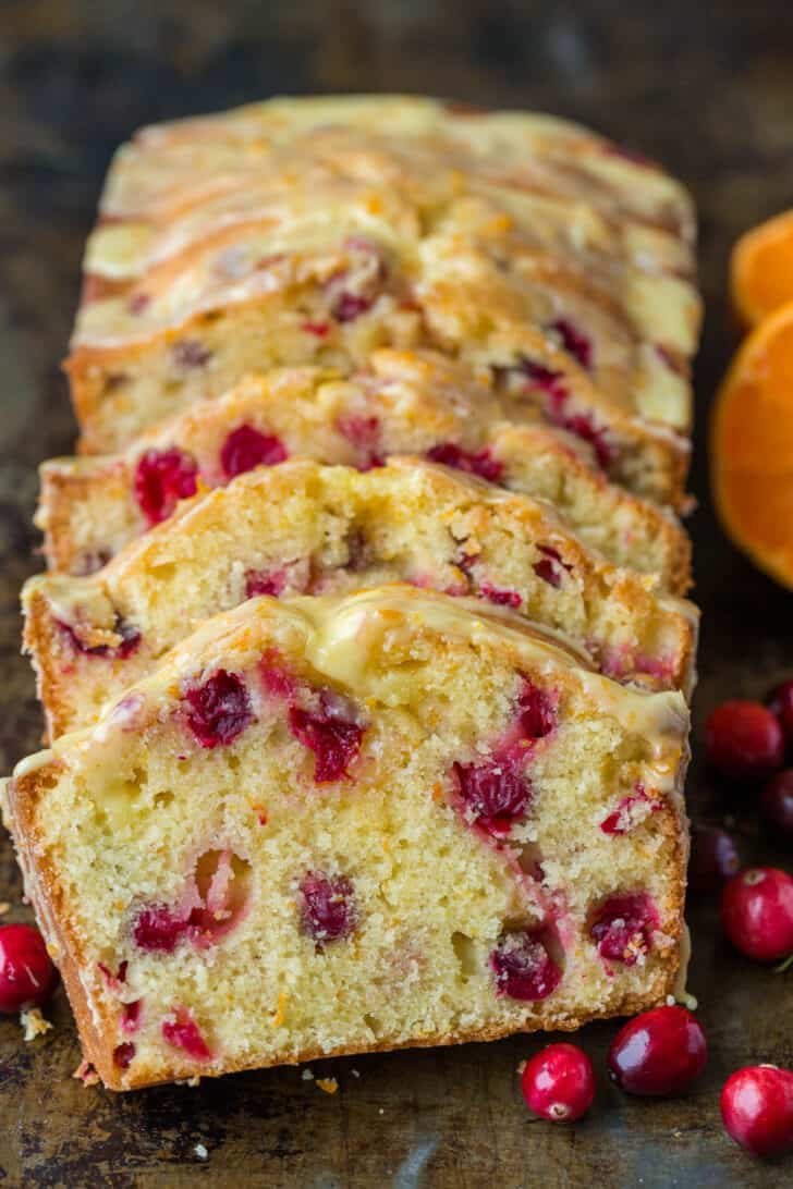 Orange-glazed Cranberry bread with a moist and tender crumb and loaded with juicy cranberries. The cranberry loaf stays moist for days. Sliced cranberry bread with fresh cranberries