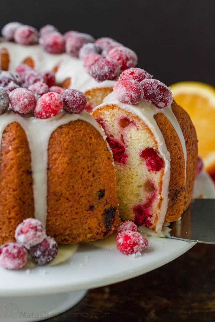 Cranberry Orange Bundt Cake on a platter with slice removed