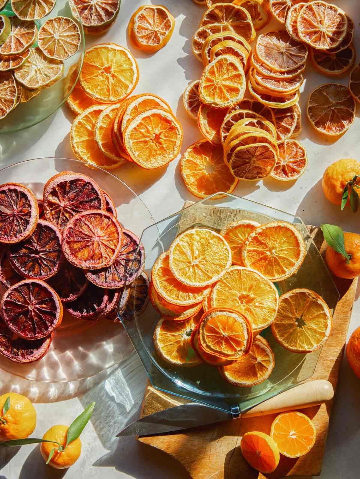Dehydrated citrus on a surface on plates with fresh citrus. 