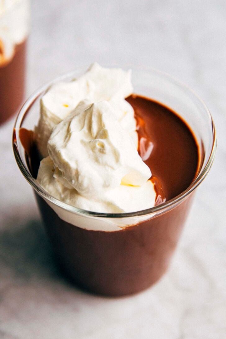 close up photo of french hot chocolate in a clear glass with whipped cream