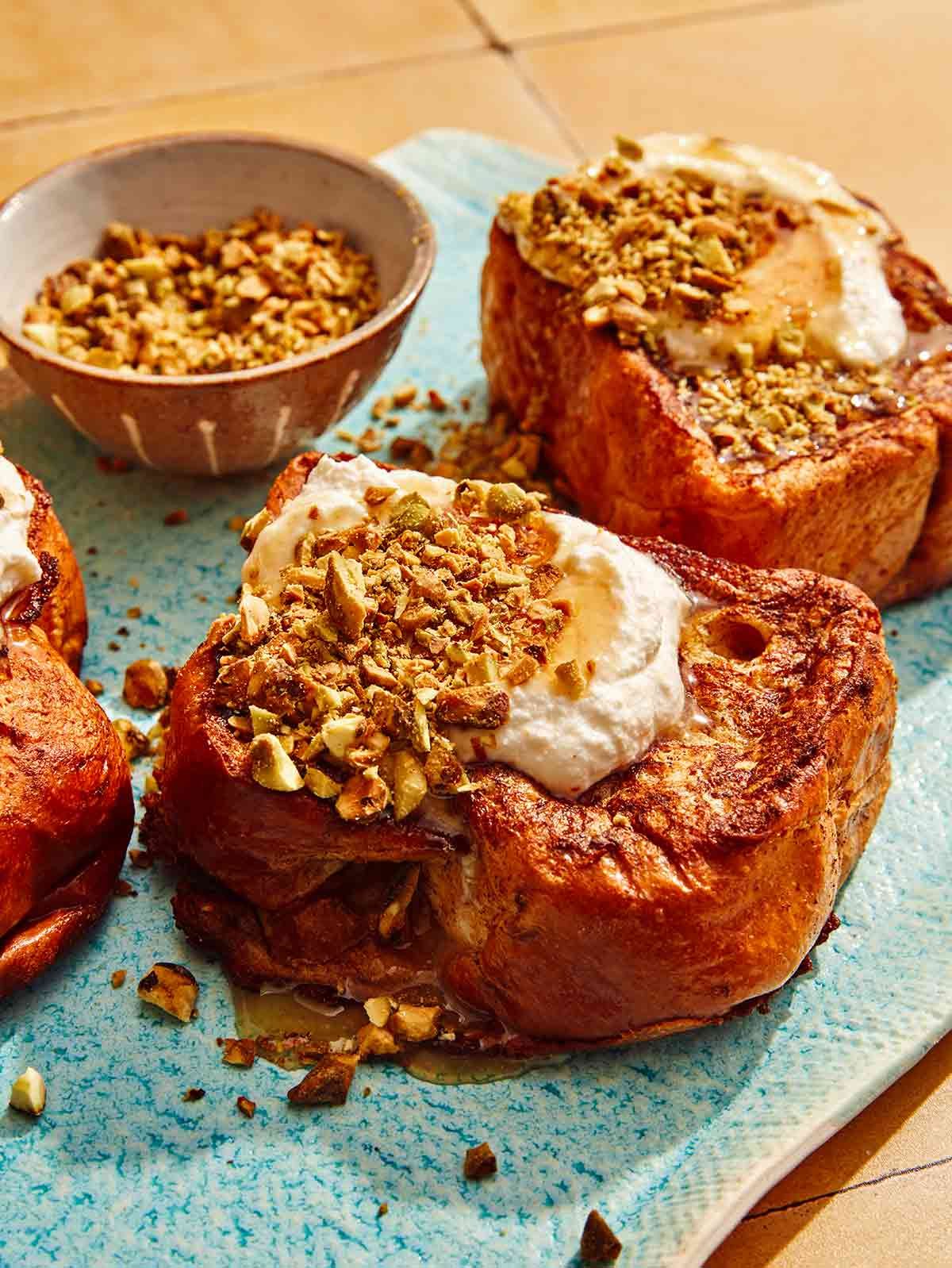 French toast on a platter with nuts on the side. 