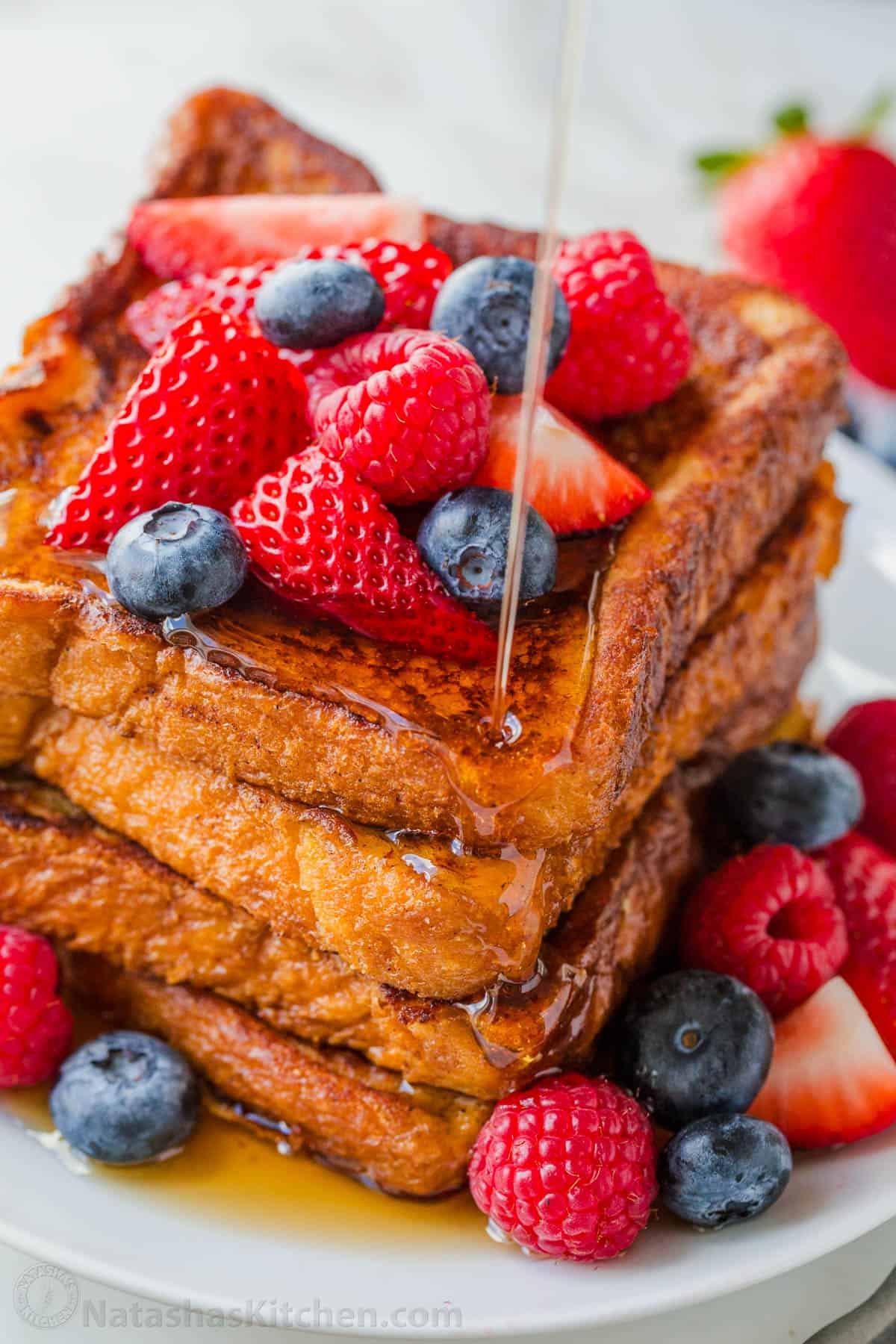 This will be your go-to French Toast Recipe. From the batter to the cooking method, it's easy, excellent, and works with a variety of bread. Stacked French toast drizzled with maple syrup and topped with berries