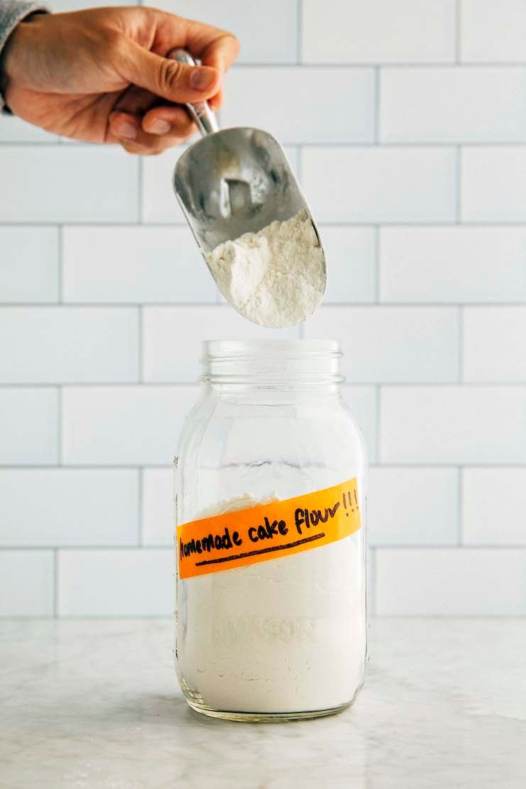 hand scooping homemade cake flour from jar