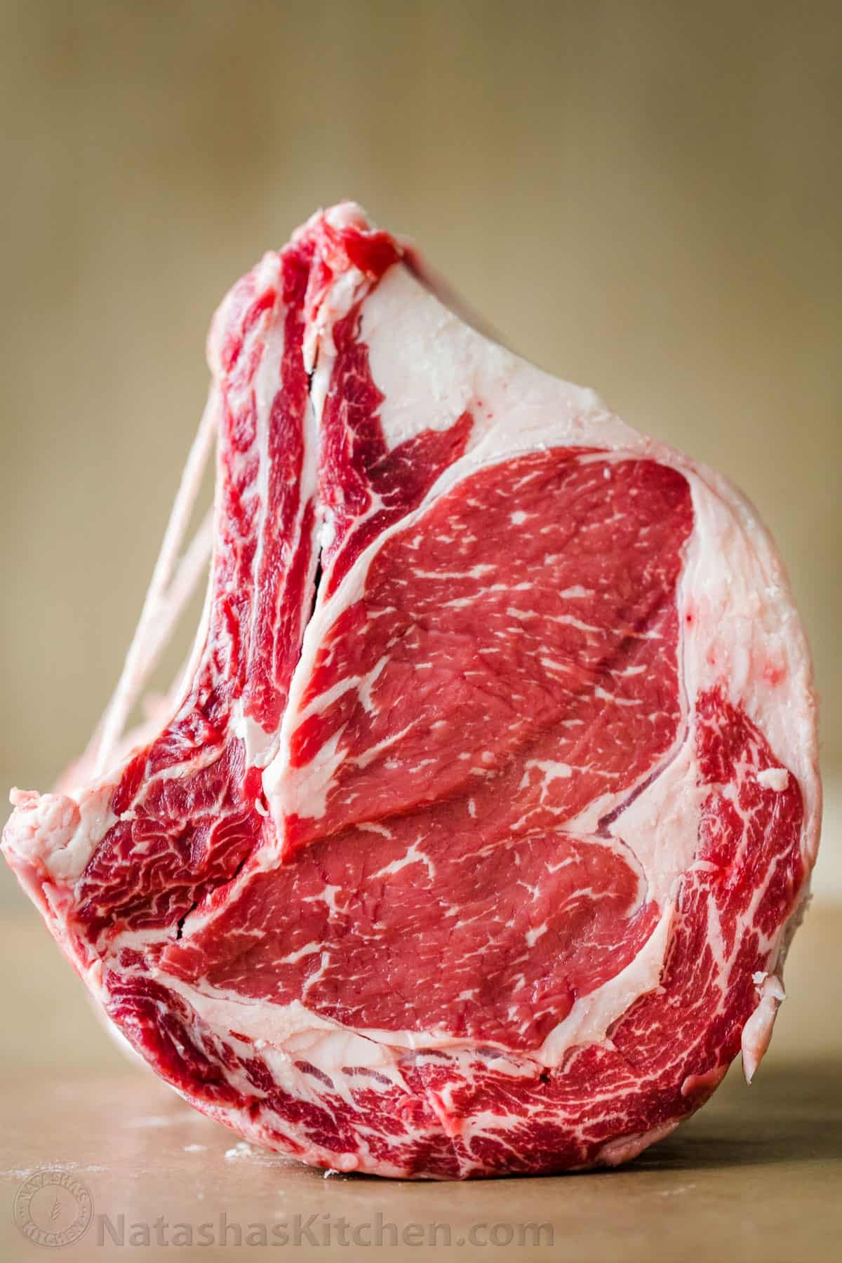 Everything you need to know to purchase the perfect Prime Rib Roast, from beef quality grades, bone-in vs boneless, and how big of a roast you need. #primerib #primeribroast #howtobuyprimerib #howtoselectprimerib #primeribrecipe #natashaskitchen Prime Rib Roast tied with string