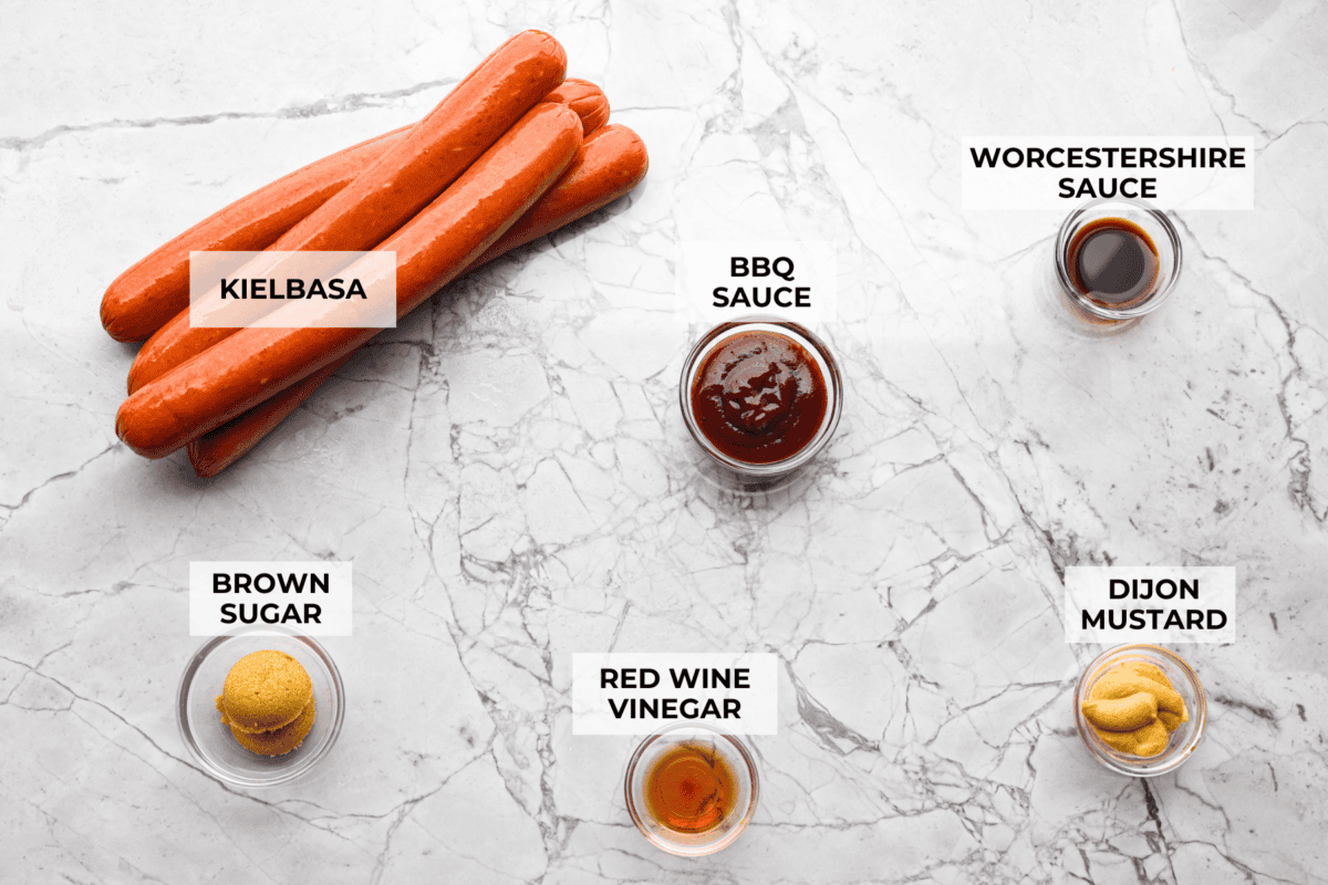 Kielbasa Bites are the ultimate crowd-pleasing appetizer! With their smoky, savory flavor and caramelized glaze sweetness, these bite-sized snacks are easy to make and always a hit at parties, game days, or anytime you need a quick appetizer! Overhead shot of labeled ingredients.