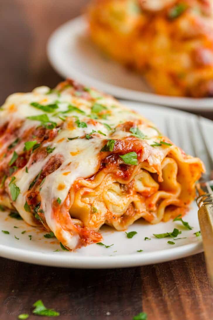 Lasagna roll ups plated and garnished with parsley. 