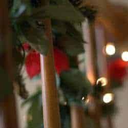 Lit garland on the stairway railing.