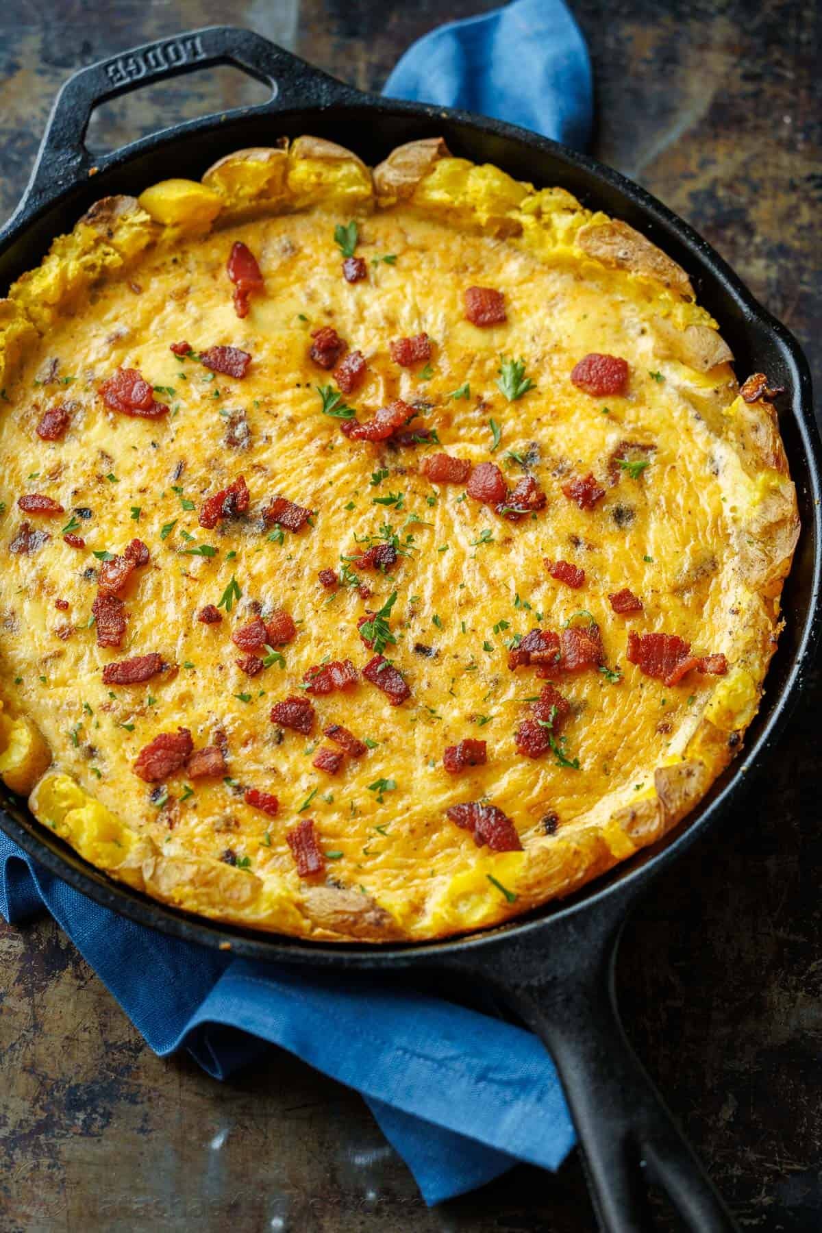 Our Potato Crusted Quiche replaces traditional dough with smashed potatoes for a tasty, gluten-free option that's easy to make and perfect for brunch. Potato Crust Quiche in a well-seasoned 10-inch cast iron skillet, topped with bacon and parsley