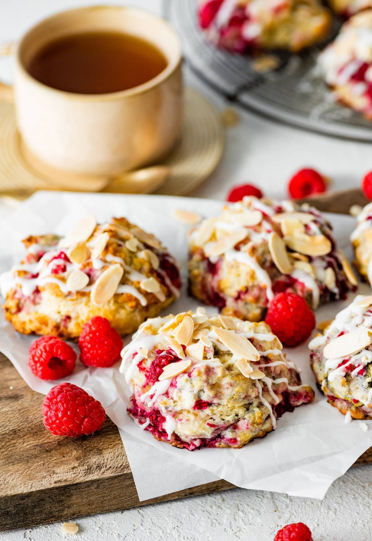 raspberry almond biscuits with almond glaze and sliced almonds with cup of coffee.