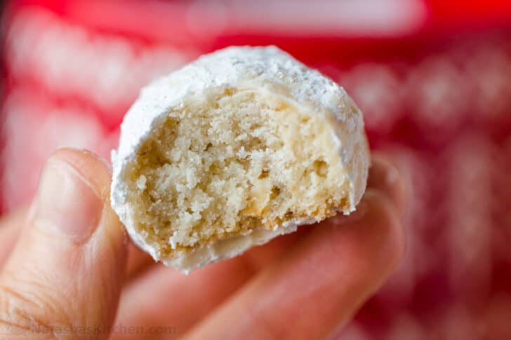 Russian Tea Cakes are easy to make and melt-in-your-mouth delicious. Add these little snowball cookies to your Christmas cookie platter. Center of a Russian tea cake cookie