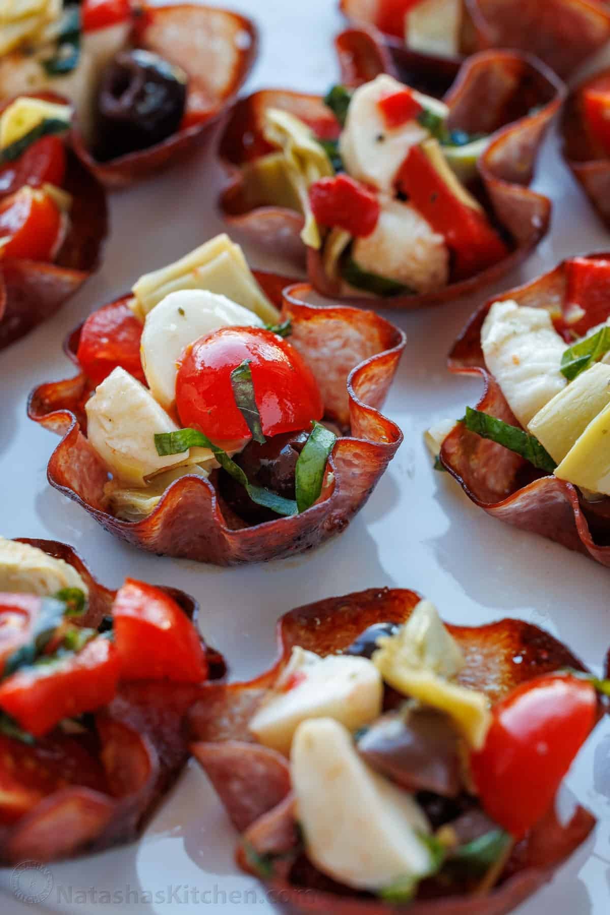 This Salami Cups appetizer recipe is bite-sized perfection! Thin salami baked into crispy cups, filled with your favorite cheeses, antipasto, and herbs. Salami Cups Antipasto