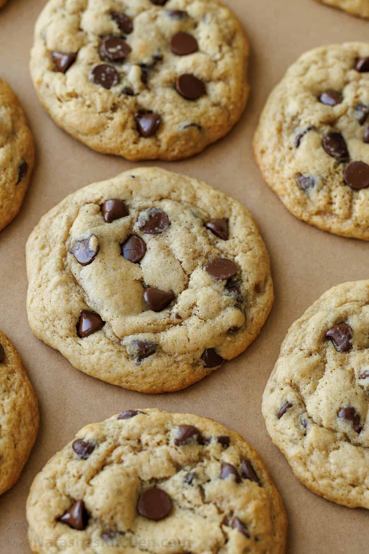 Soft-chewy sourdough chocolate chip cookies made with discard and loaded with chocolate chips. Step-by-step photos and easy video tutorial. Sourdough discard cookies lined up on a baking tray