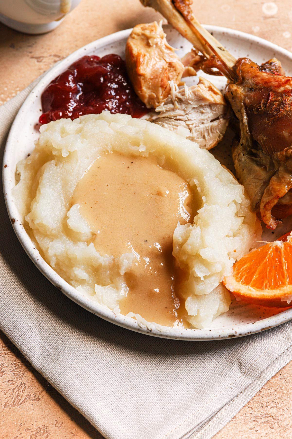 Plate of turkey, cranberry sauce, mashed potatoes, and turkey gravy.