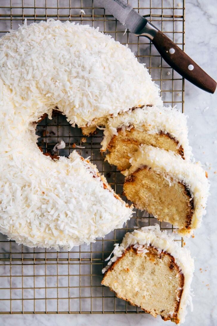 closeup photo of coconut bundt cake sliced on a wire rack