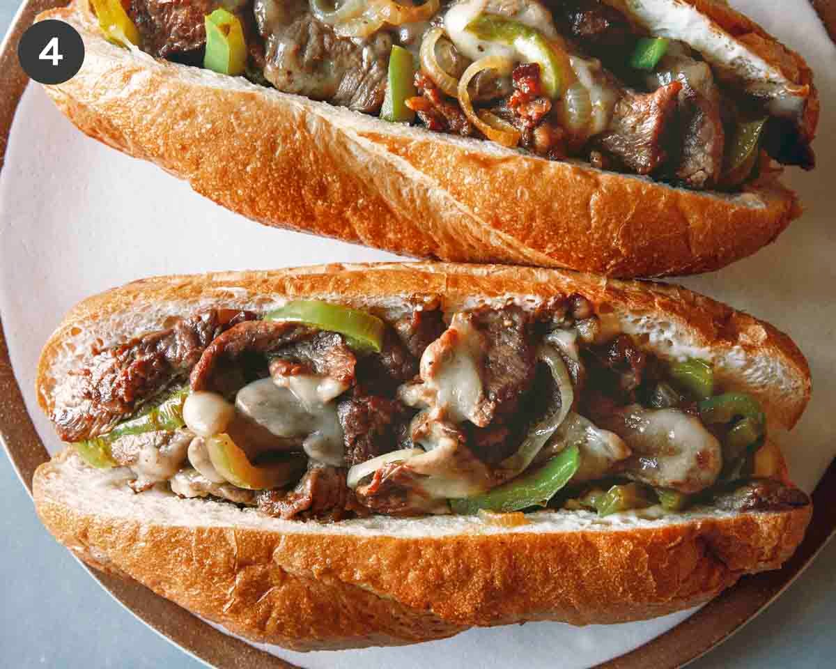 Two Philly Cheesesteak sandwiches on a plate.