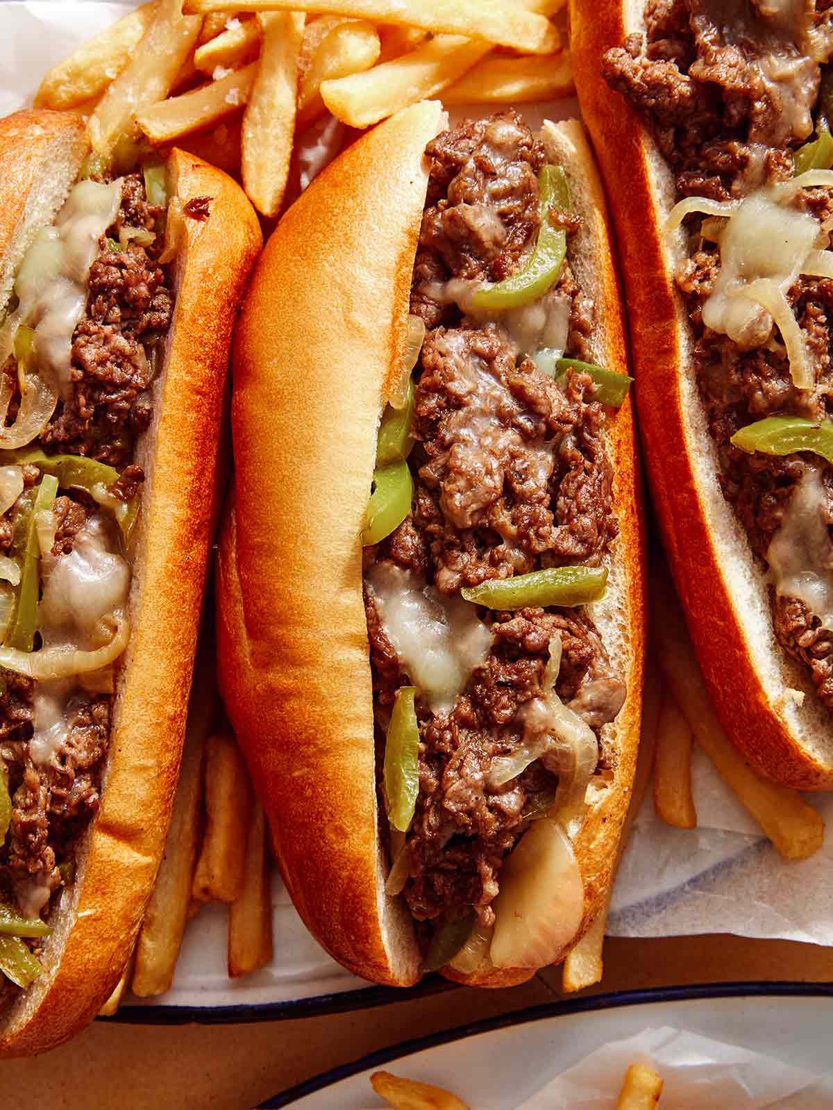 Close up on a platter of Philly cheesesteak sandwiches.