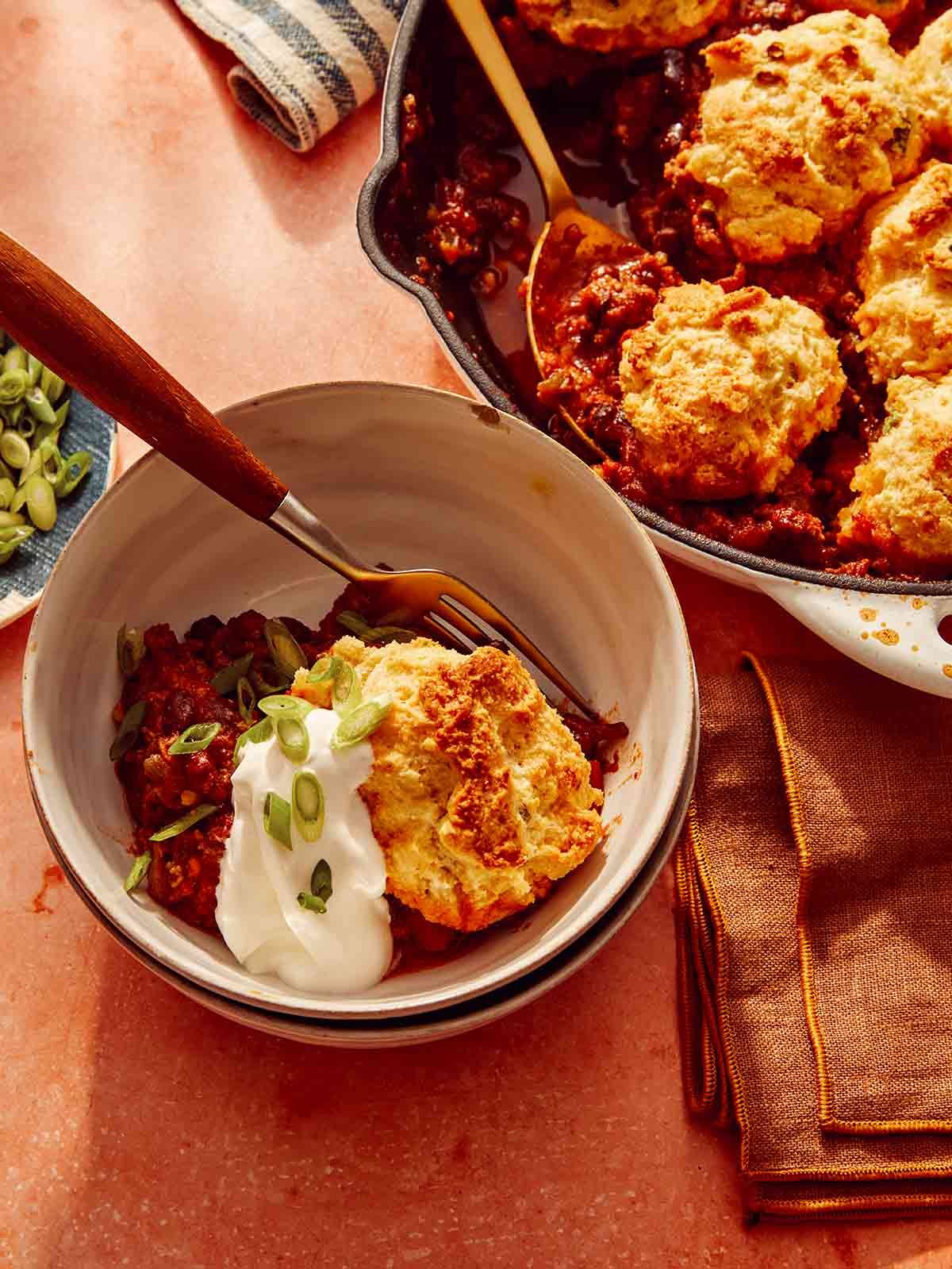 Chili cornbread casserole in a bowl with the skillet next to it.