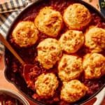 Chili Cornbread Casserole in a skillet with a scoop taken out.