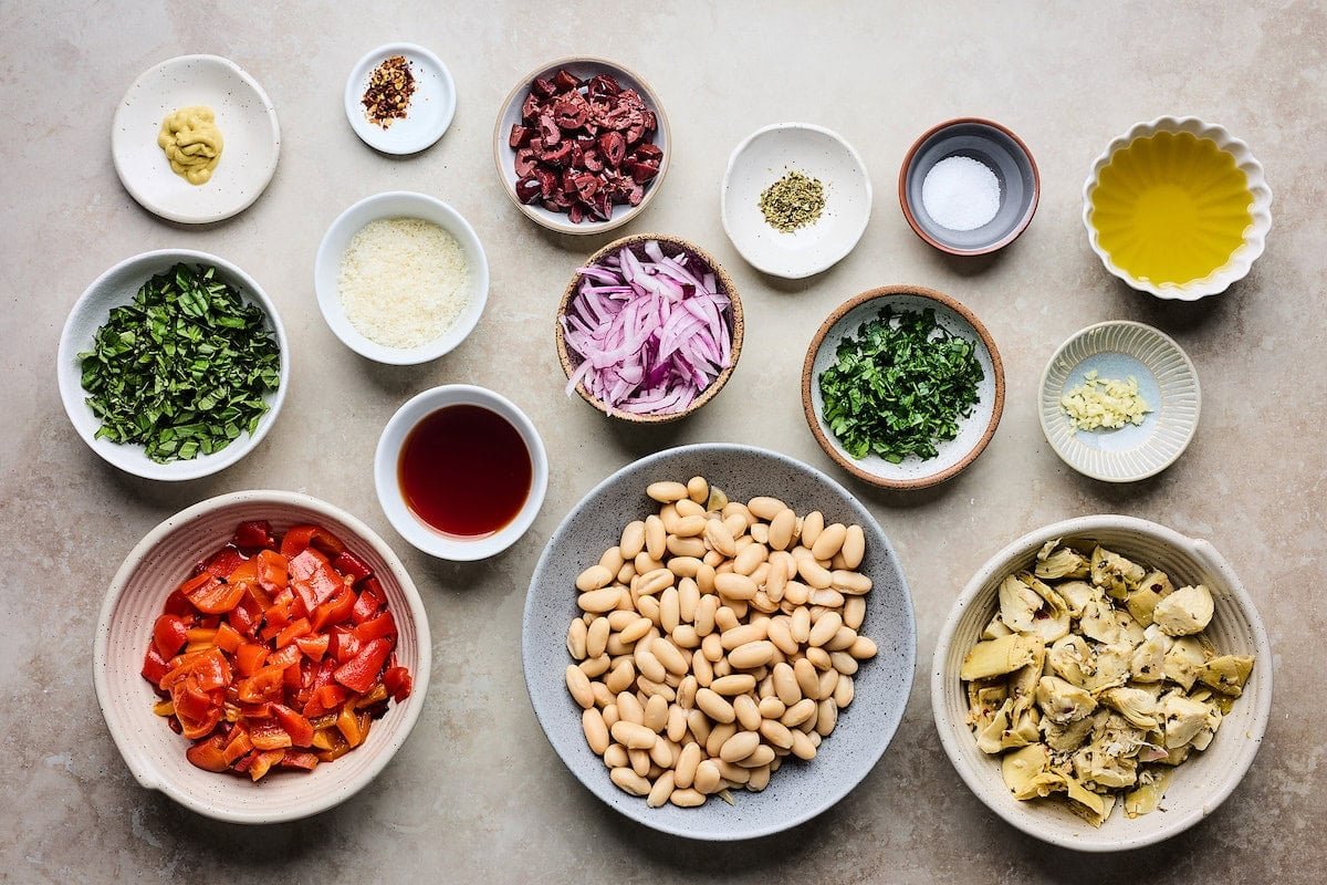 ingredients in bowls to make Marinated Artichoke, Roasted Red Pepper & White Bean Salad.