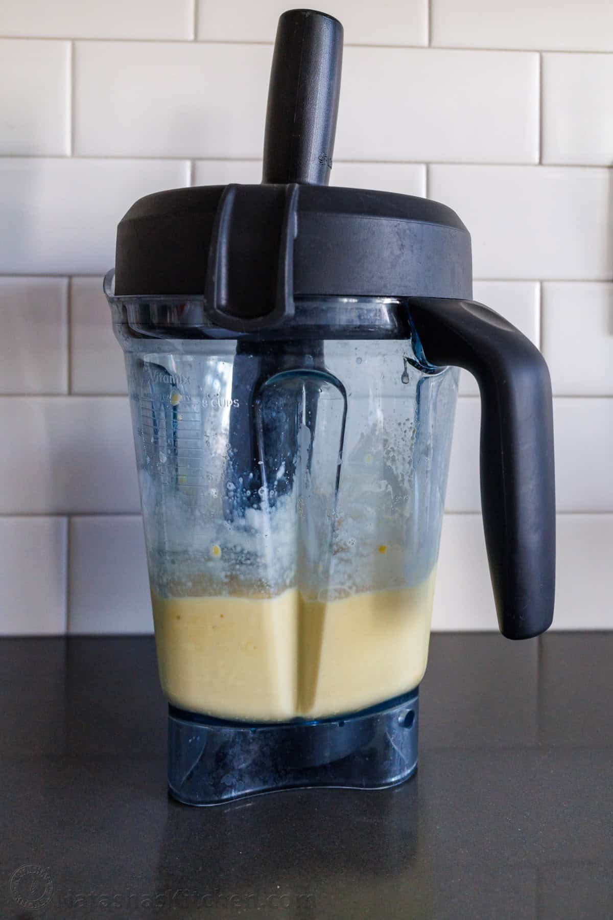 Easy Tropical Mango Smoothie recipe uses just 6 ingredients, like mango, lime, banana, and Greek yogurt, and takes under 5 minutes to make! Blender with a tamper accessory blending yellow mixture