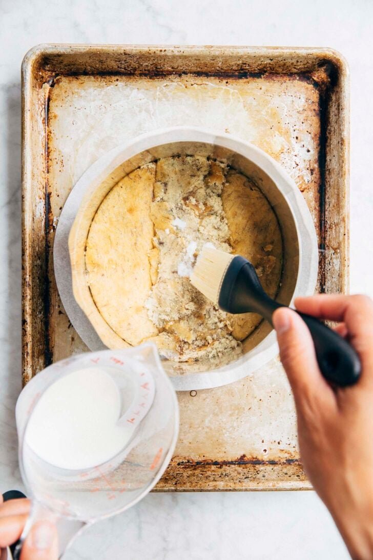 photo showing the first layer of the milk bar banana cake being soaked with milk