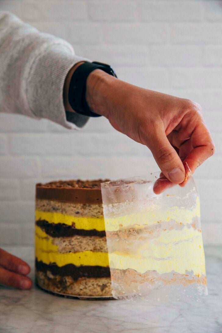 photo of Michelle removing the acetate paper from the assembled layer cake