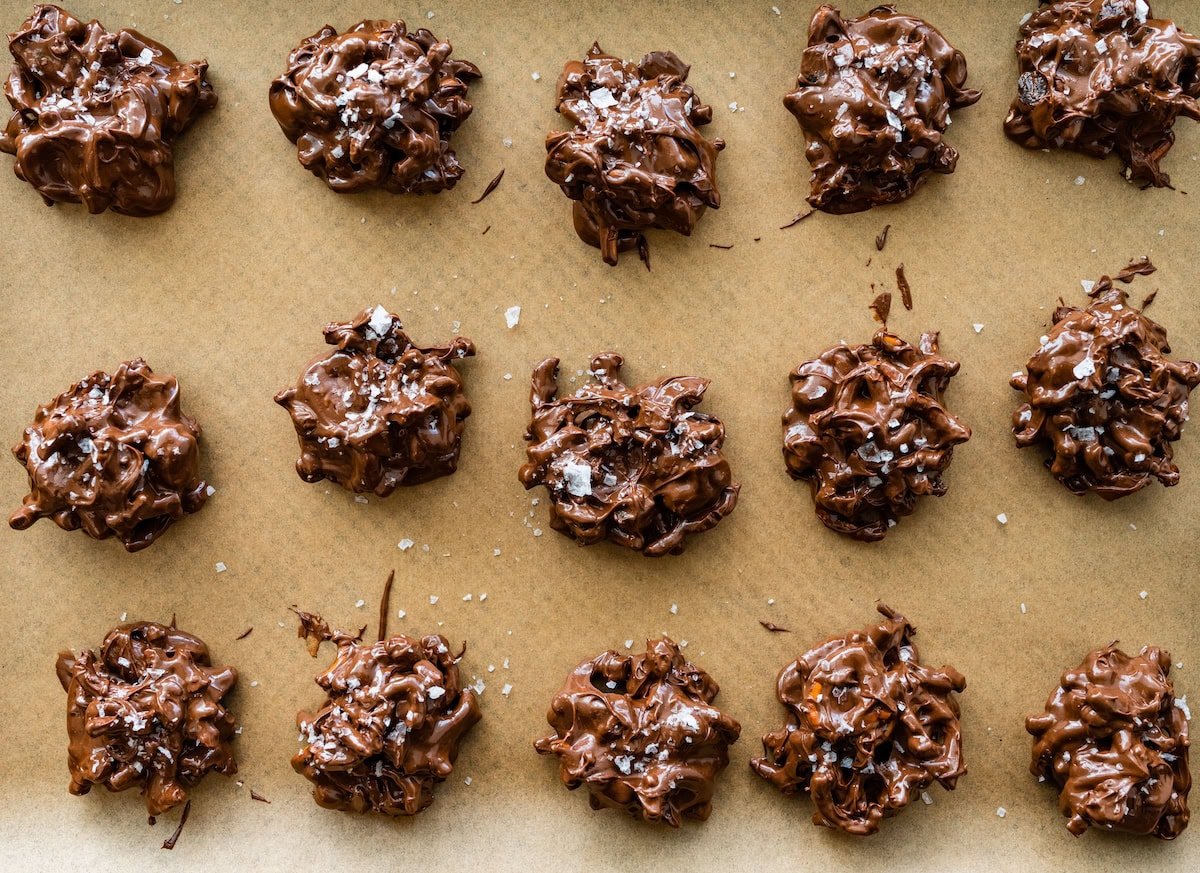 peanut butter pretzel date clusters with flaky sea salt on baking sheet.