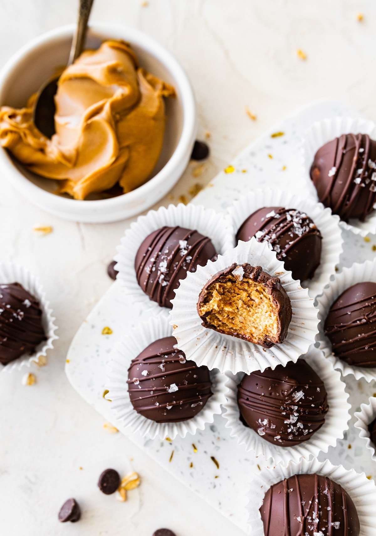 chocolate dipped peanut butter protein balls in mini paper cups.