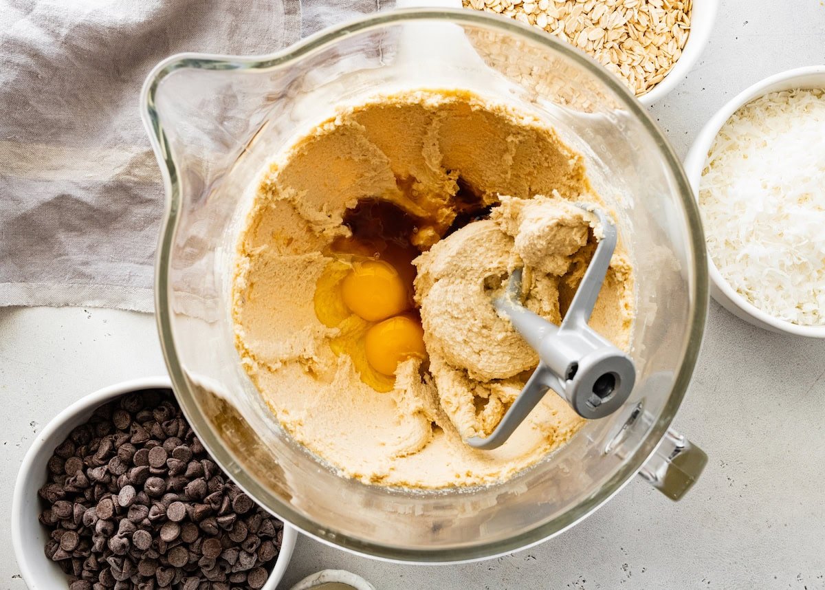 creaming butter and sugars together in mixing bowl and adding eggs and vanilla extract.