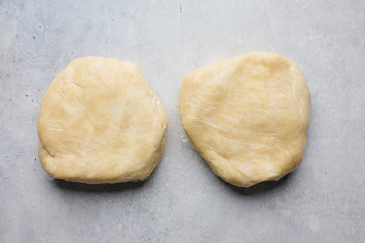 2 pie dough disks wrapped in plastic wrap.
