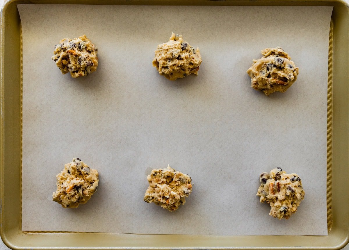 pretzel toffee chocolate chip cookie dough balls on baking sheet with parchment paper.