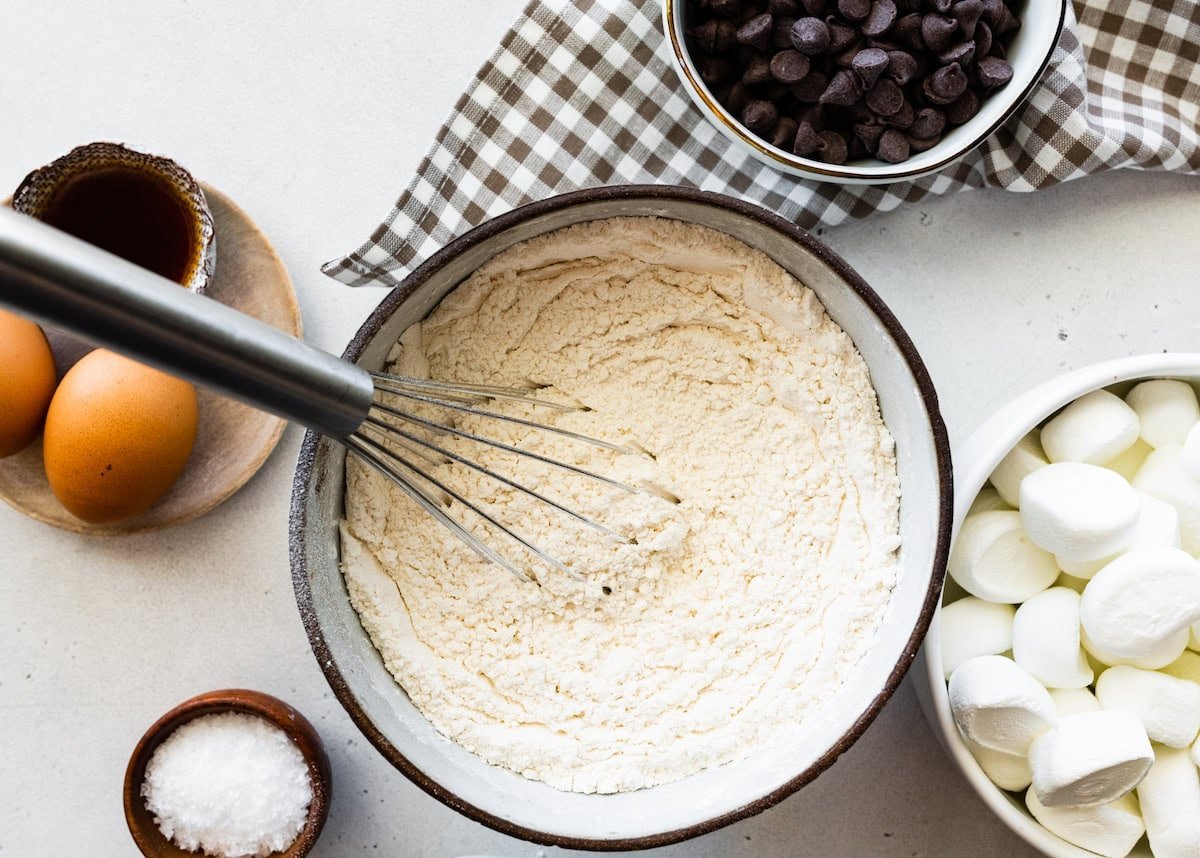 dry ingredients being whisked together in bowl with whisk. 