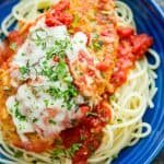chicken parmesan recipe served over pasta in a blue bowl