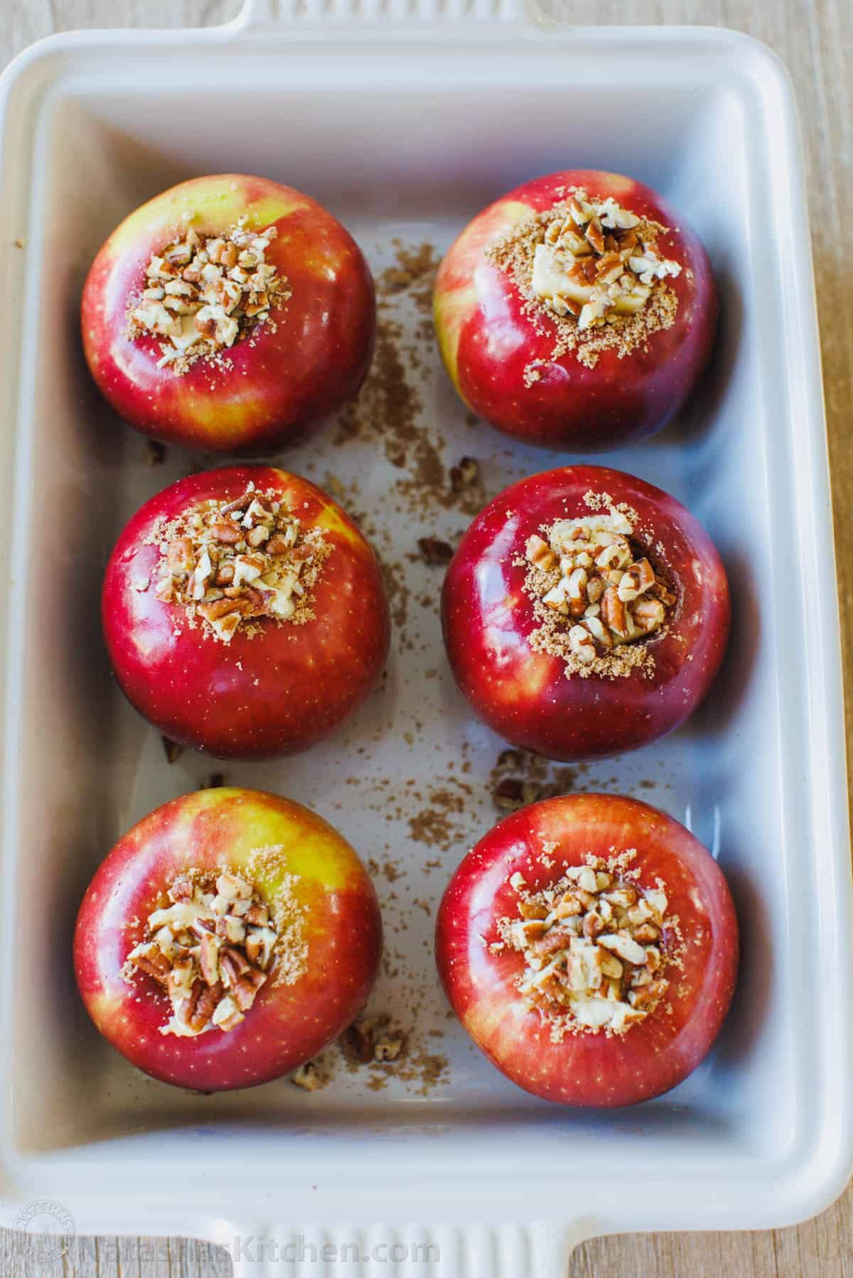 Stuffed Baked Apples are the ultimate fall treat Unbaked apples stuffed with cinnamon sugar filling arranged in a baking dish.