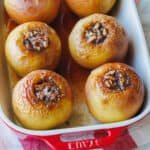 Baked apples filled with cinnamon sugar in a rectangular baking dish.