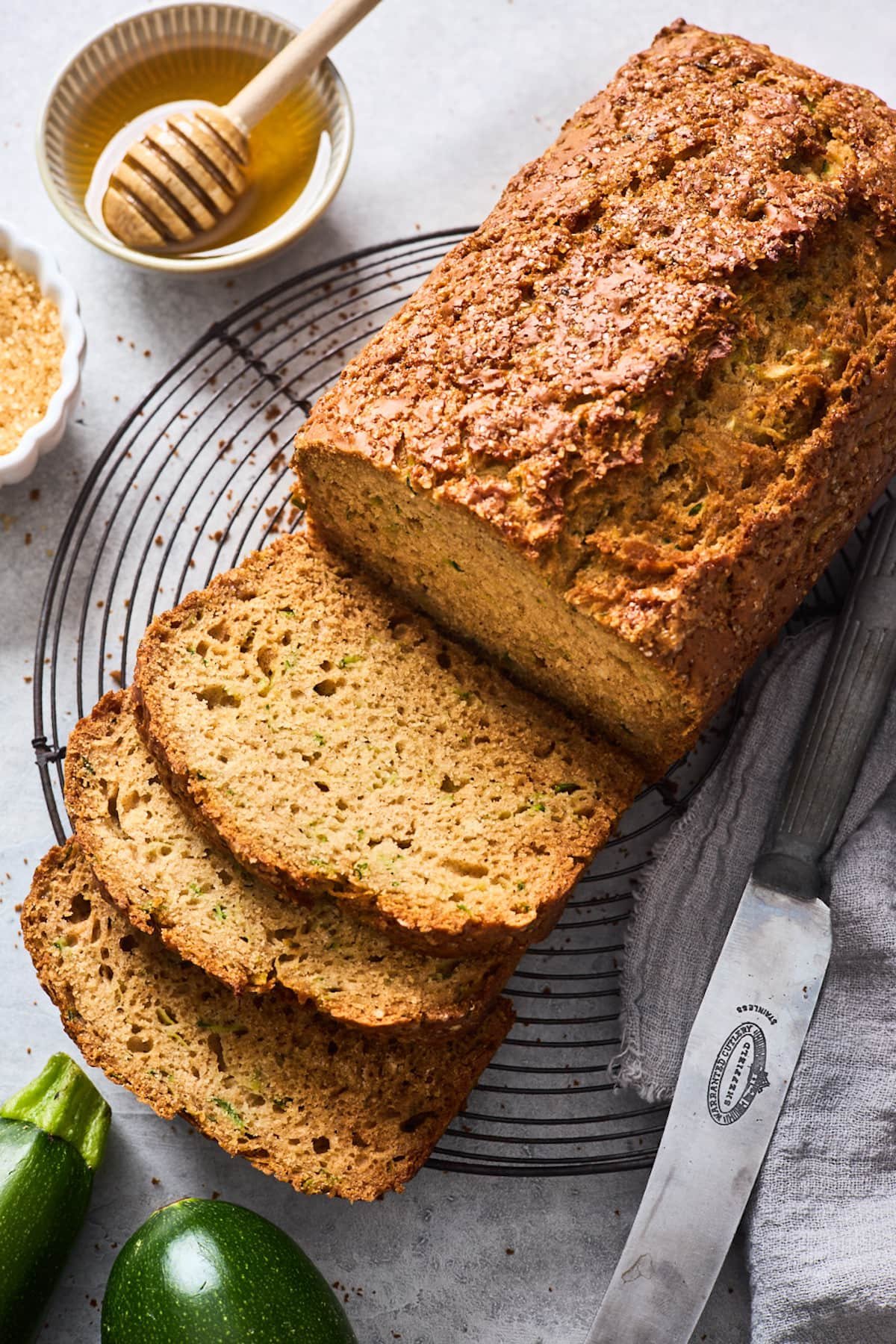 healthy zucchini bread on cooling rack cut into slices with knife.
